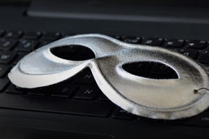 Mask on laptop keyboard - Concept of privacy, security and anonymity of computer users