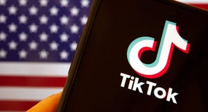 Cellphone with the TikTok icon in front of the flag of America.