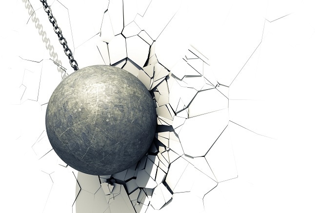 wrecking ball shattering a white wall