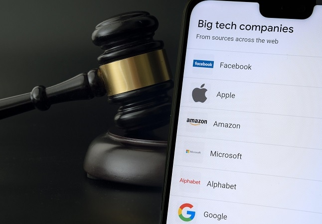 Smartphone with the list of companies placed next to the judge gavel