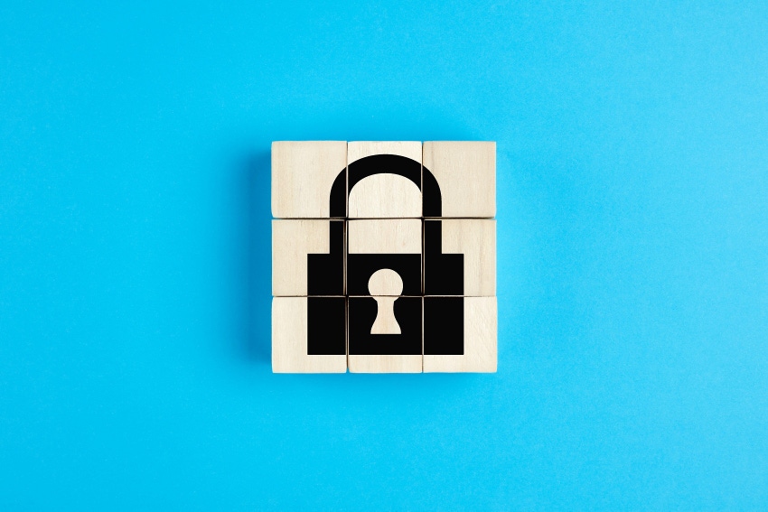 Lock icon on wooden cubes on blue background. Isolation, quarantine or data security concept.