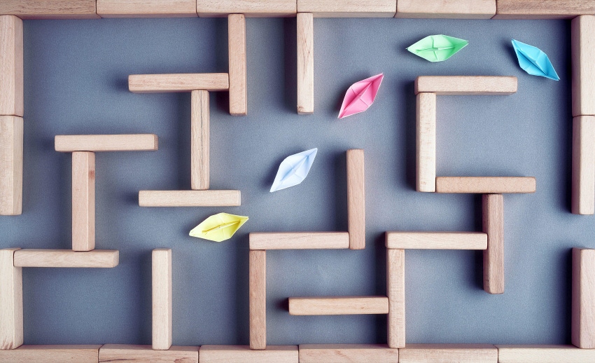 colorful paper boats going through a wooden maze