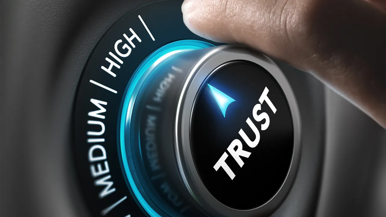 A hand turns a dial labeled 'trust' up A hand turns a dial labeled 'trust' up
