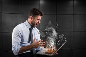 Businessman expressing stress and frustration caused by a computer