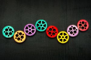 Line of colored gear wheels as symbol of teamwork and creativity.