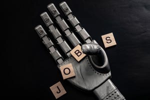 concept with a robot hand grabbing wooden tiles that spell out the word JOBS on