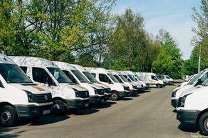 commercial vans lined up in a parking lot