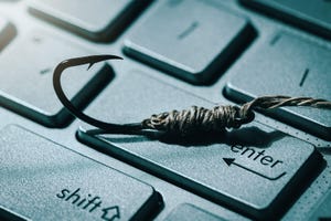 phishing and cyber crime concept. fishing hook on computer keyboard 