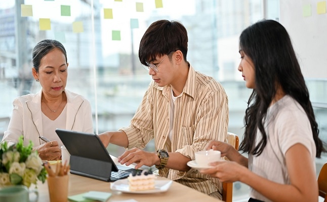 young male software engineer working with senior female product manager and young female worker in the office.