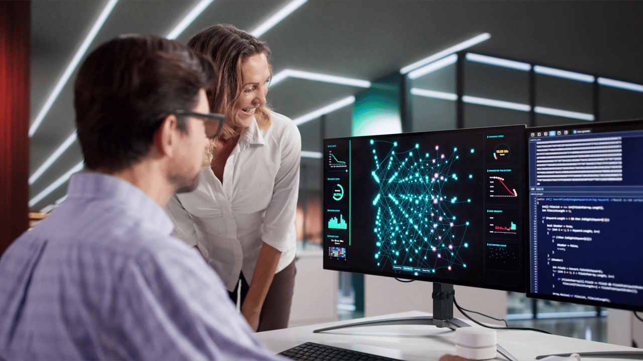 Two IT professionals work on an AI model at a computer Two IT professionals work on an AI model at a computer