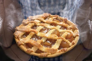 Apple Pie With Steam Being Held By Baker