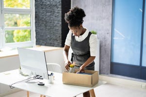 young professional woman quitting her job and packing up her desk