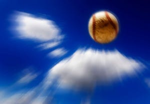 Baseball flying through the air with clouds and sky in background zooming action big hit