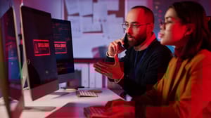 Portrait of agitated cybersecurity team working in emergency mode with critical error message on computer screen Portrait of agitated cybersecurity team working in emergency mode with critical error message on computer screen