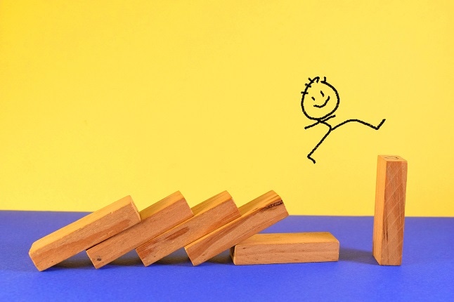 stick figure gleefully jumping up on wooden blocks. bright yellow background