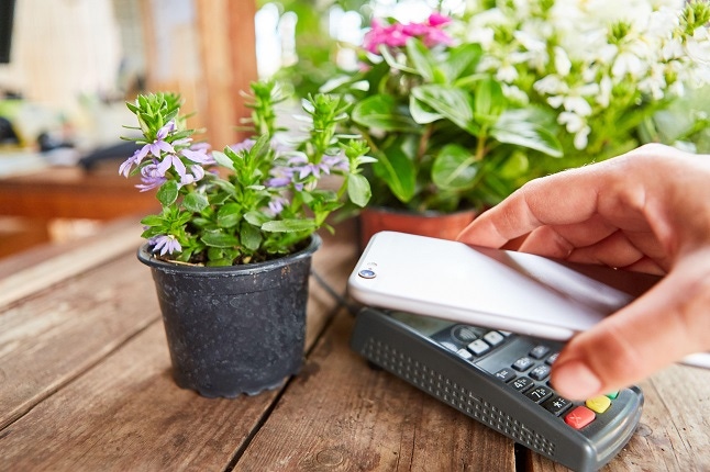 person making a mobile payment at a flower shop