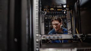 An IT executive works inside a server rack in a data center An IT executive works inside a server rack in a data center