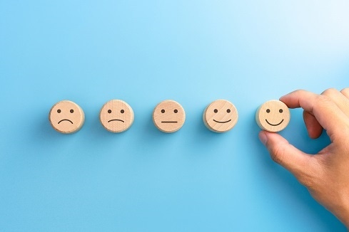 customer experience abstract with a range from frowning to smiling faces as ratings