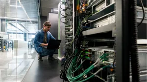 A computer technician fixes a network server in an office A computer technician fixes a network server in an office