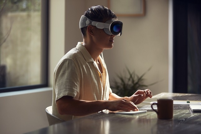 A person does work while using an Apple Vision Pro headset.