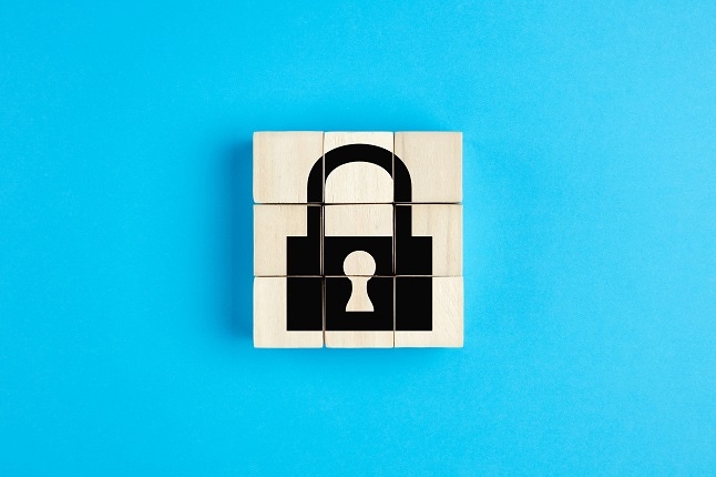 Lock icon on wooden cubes on blue background. Isolation, quarantine or data security concept.