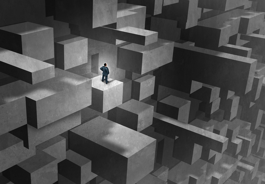 Illustration of a person in a blue suit standing on a block in a huge gray maze.