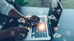 An IT executive works at a laptop, with icons for SaaS and AI, among others, overlaid An IT executive works at a laptop, with icons for SaaS and AI, among others, overlaid