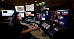 Young woman working in the control room center for emergency service dispatch.