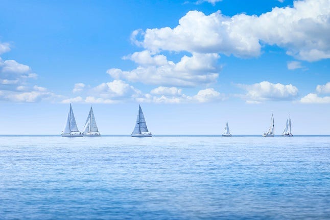 Sailing boat yacht or sailboat group regatta race on sea or ocean water.