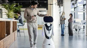 A man walks with a robot through a contemporary office space A man walks with a robot through a contemporary office space