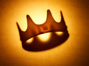 a gold crown against a light gold backdrop