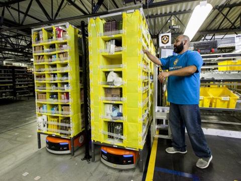 Amazon employee picks items from a Kiva robot in its Seattle distribution center. (Source: Amazon, via Business Wire)