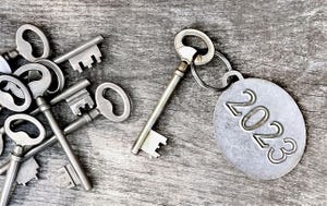 2023 engraved on a ring of an old key on wooden background