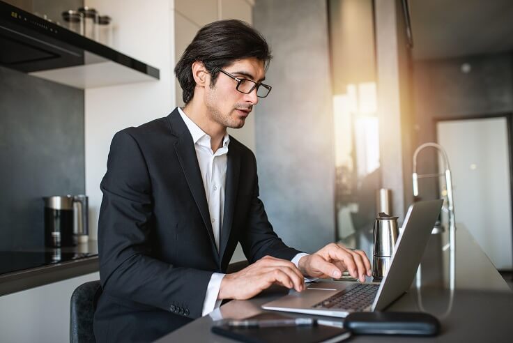 Businessman works from remote at house with a laptop due to coronavirus quarantine. Businessman works from remote at house with a laptop due to coronavirus quarantine.