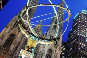 A sculpture of the Greek god Atlas holding the world stands in Rockefeller Center across the street from St Patrick's Cathedral in New York City
