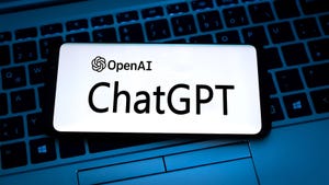Smartphone with OpenAI and ChatGPT logos sitting on a computer keyboard