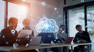 Five executives sit at a conference room table, with an illustration of a digital cloud overlaid. Five executives sit at a conference room table, with an illustration of a digital cloud overlaid.