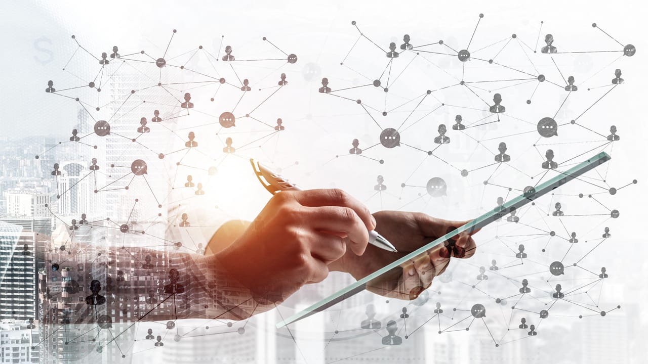 An IT executive holds a tablet, with an overlay of workers connected by lines An IT executive holds a tablet, with an overlay of workers connected by lines