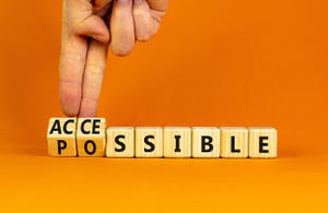 Businessperson turns wooden cubes and changes the word possible to accessible. Business and possible or accessible concept