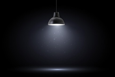 black room with single lightbulb lamp implying divulging secrets