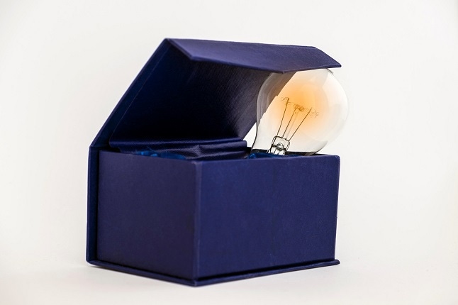 abstract of thinking outside of the box (lightbulb peeking out of a blue box)