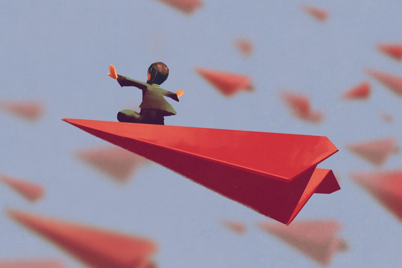 man sitting on red airplane paper in the sky