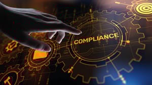 A hand reached out to touch a screen that reads 'Compliance' A hand reached out to touch a screen that reads 'Compliance'