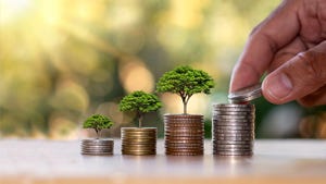 Financial growth concept from business investment, coin pile with small tree growing on coin and hand holding coin.