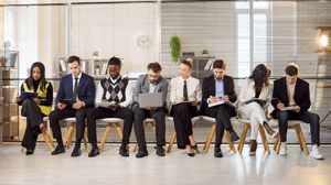 Group of job candidates in lobby waiting for interview and filling paperwork Group of job candidates in lobby waiting for interview and filling paperwork