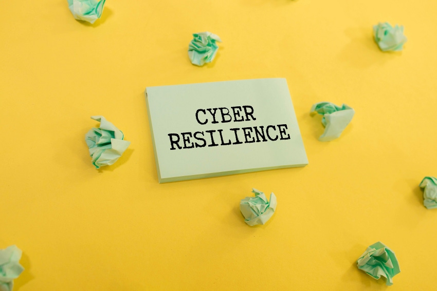 cyber resilienct text on yellow background with crumpled paper strewn about