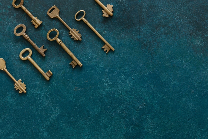 Pattern of many different antique keys on a turquoise blue backdrop