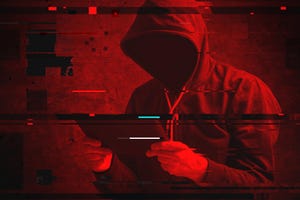 Cyber attack with unrecognizable hooded hacker using tablet computer, digital glitch effect