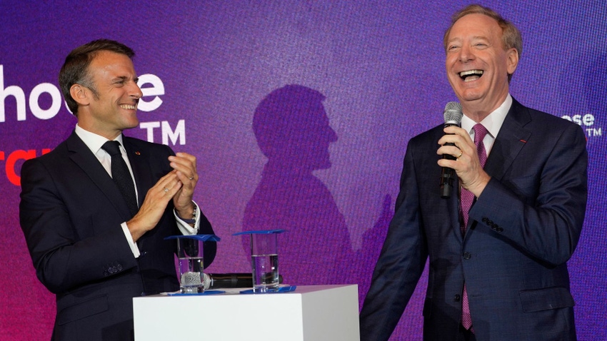 Two men stood on a stage laughing manically