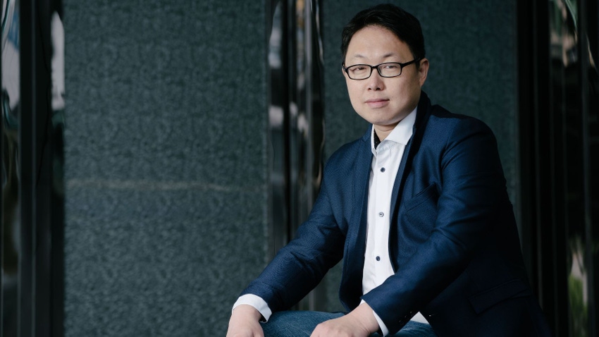 Kneron CEO Albert Liu wearing a suit and glasses